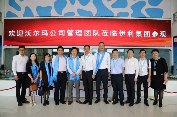 1531128160769027082.png Yili’s and Walmart’s executives pose for a photograph when visiting Yili’s factories..png