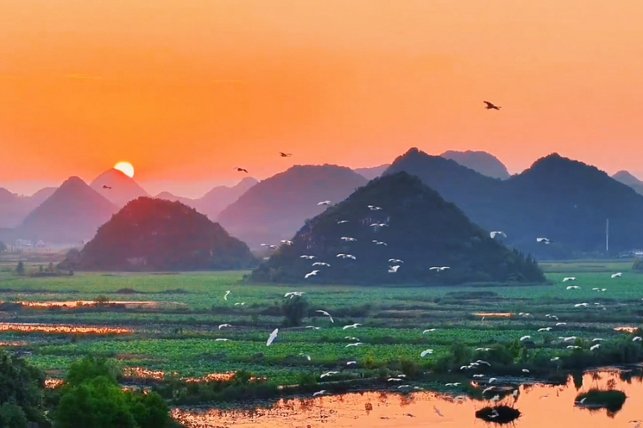 Karst peaks, warm lakes glow under Puzhehei summer sunsets