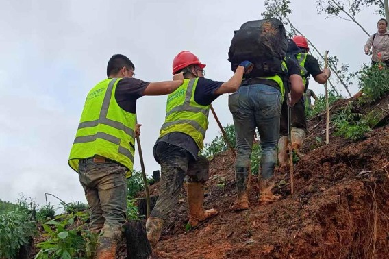 Volunteers and telecommunications workers aid flood-hit Guangxi