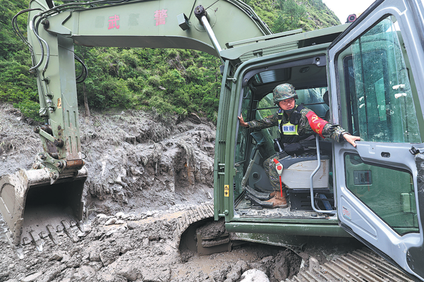 Soldiers operate heavy machinery to clear debris