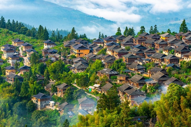 Village houses shine in morning glory in Guizhou