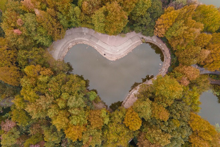 Heart-shaped lake surrounded by colorful trees in E China