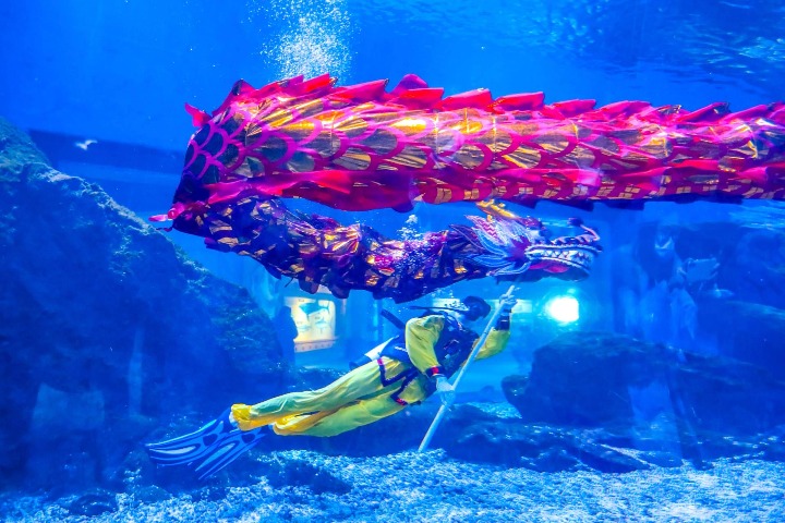 Artists perform dragon dance underwater at ocean park