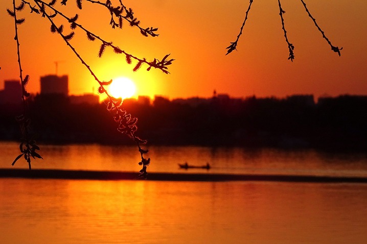 Fishing boats at the Songhua River return home in the golden sunglow