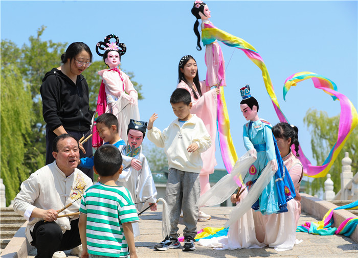 5月11日，姜玉涛和演员们在山东省莱西市月湖公园和小朋友互动。（张进刚  摄）电话13854260100.jpg
