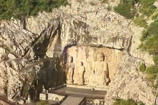 Buddha statues at Longmen Grottoes bathed in golden glow